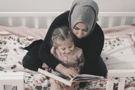 muslim woman reading to young girl