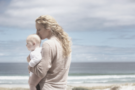 photo of mum holding baby at seaside