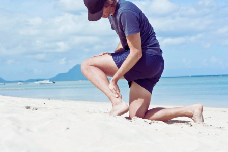 photo of man on beach with an achilles tendon injury
