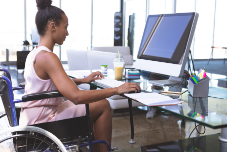 photo of lady in a wheelchair working at a desktop computer