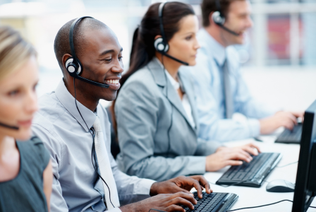 photo of staff in call centre sitting at computers with headsets on